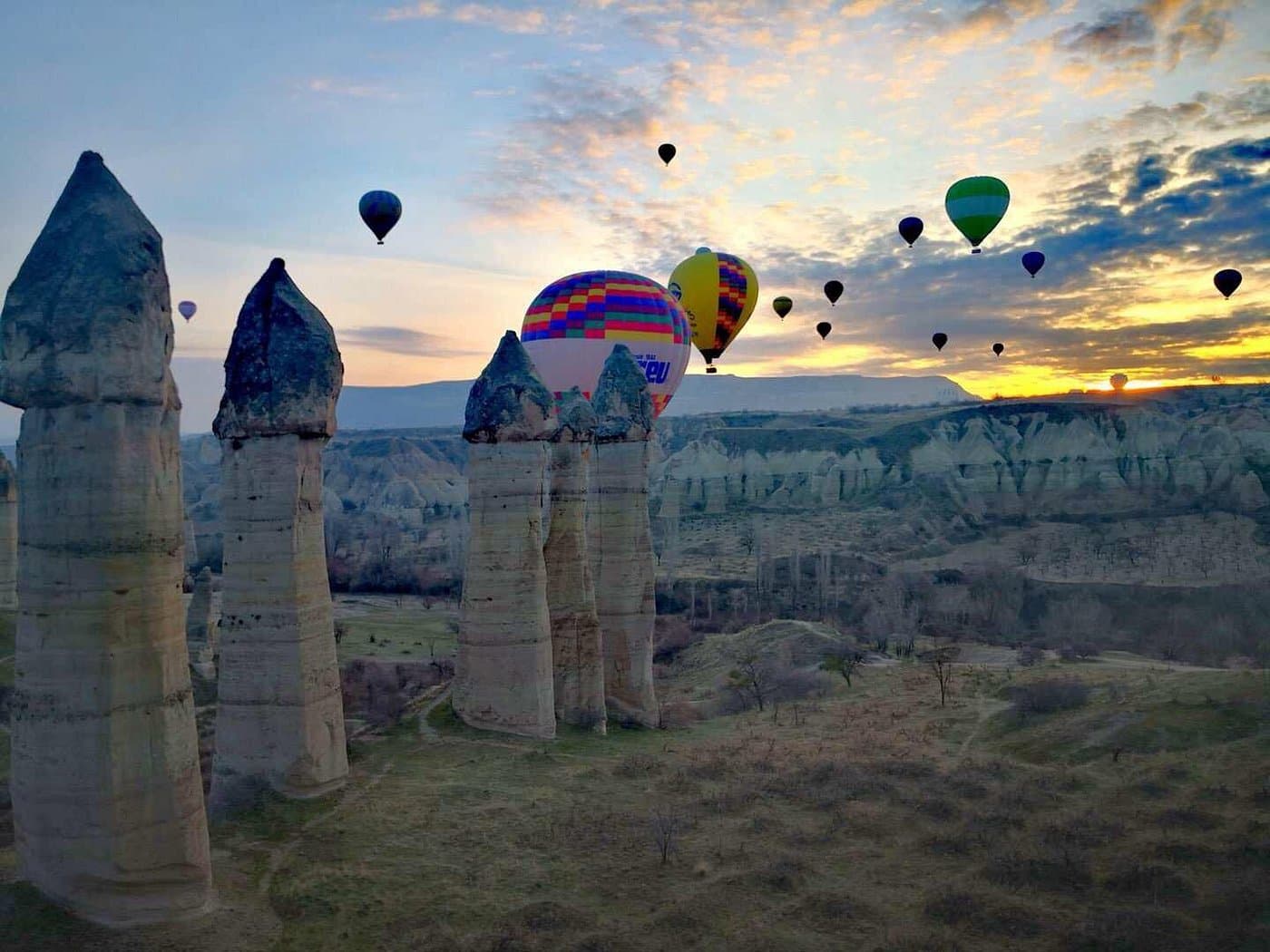 Hot air balloon baskets lined up on a Cappadocia launch field before sunrise