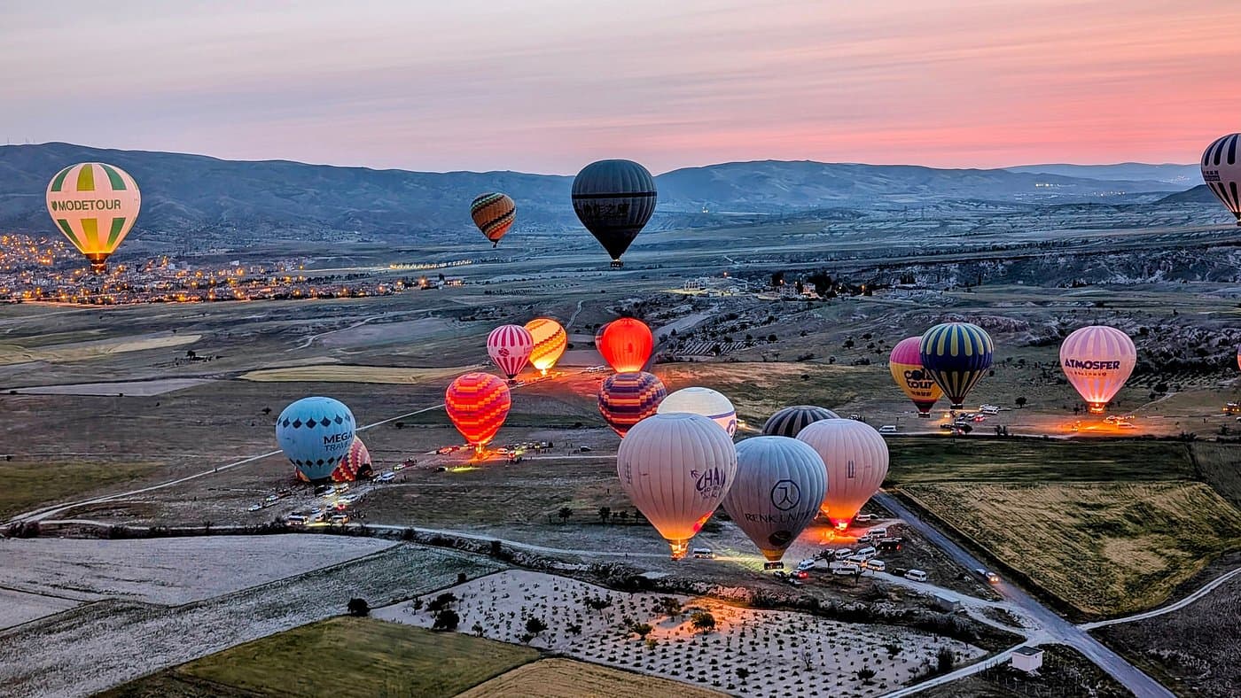 Sunrise balloon takeoff field with multiple operators preparing