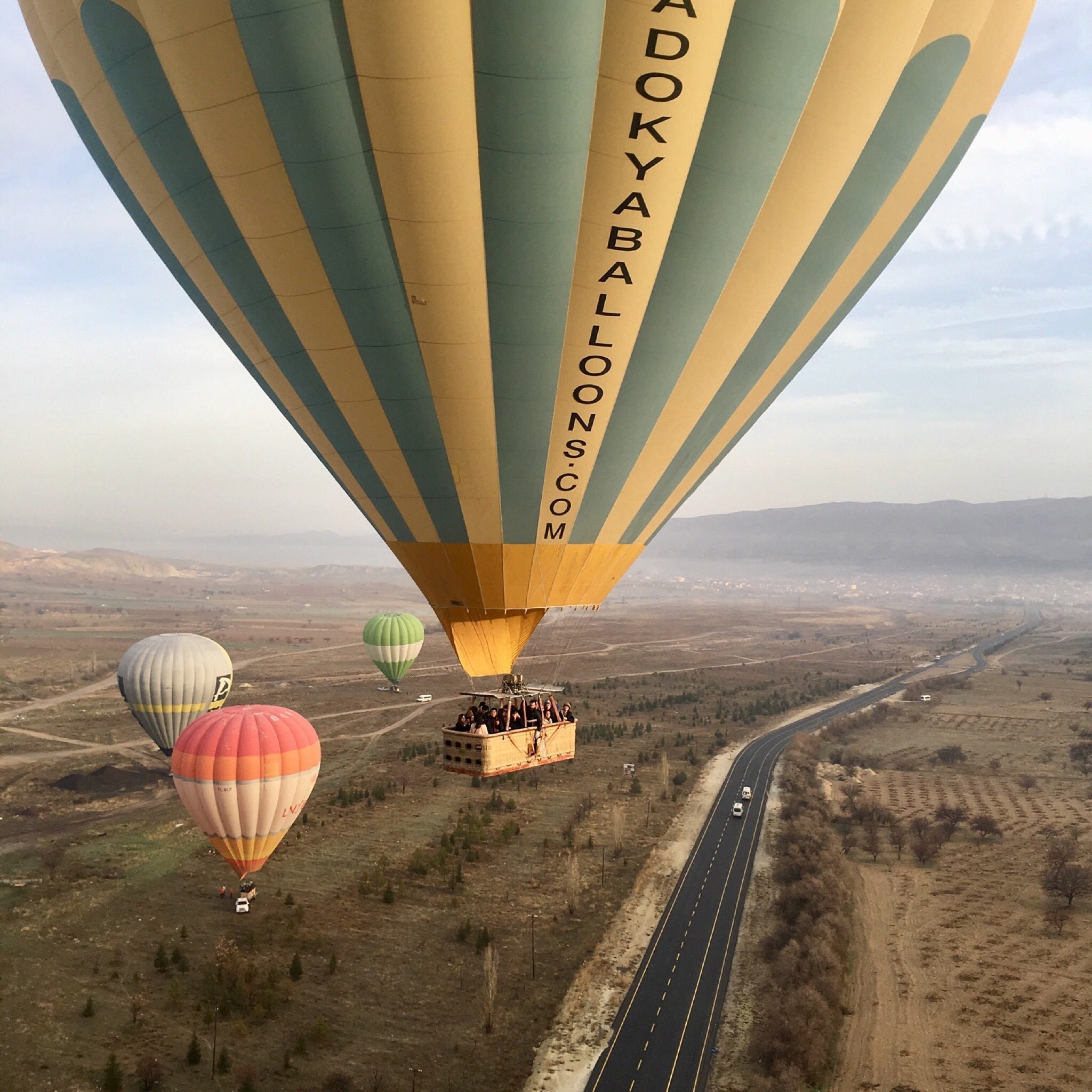A hot air balloon drifting over the Cappadocia valleys at dawn