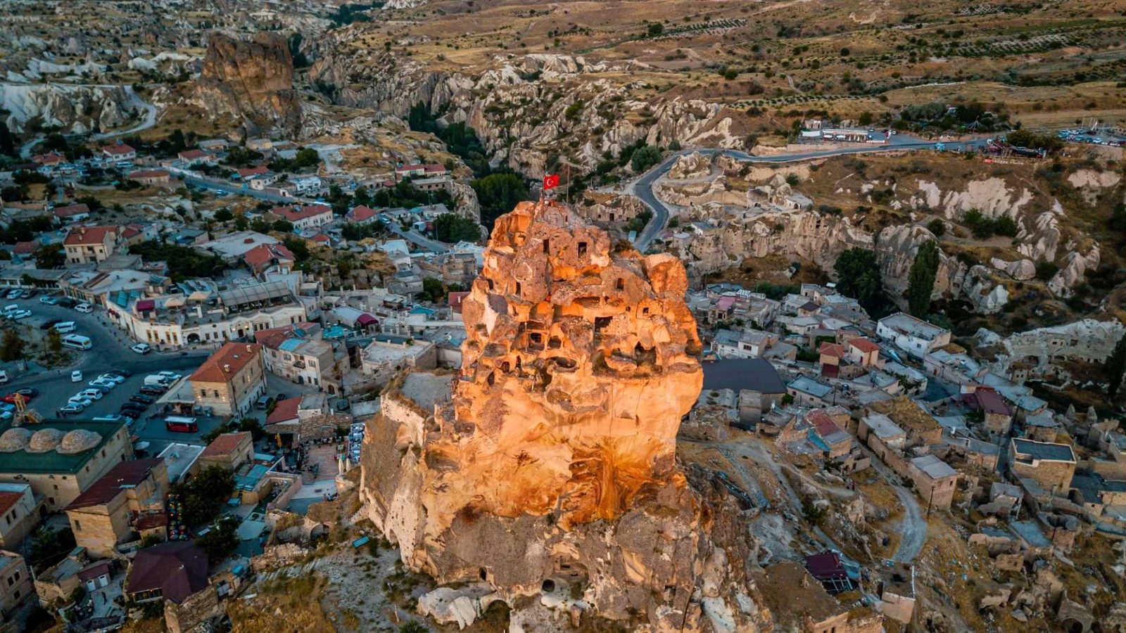 Uchisar castle at sunset above the village, the rock outcrop glowing in golden light